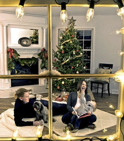 看里面的房子装饰圣诞节，父母抱着一个蹒跚学步的孩子。