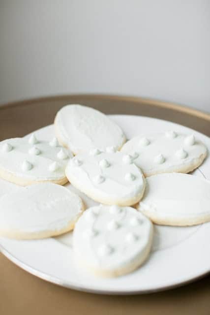 一个白色的盘子里装满了复活节彩蛋形状的白色磨砂易糖饼干。gydF4y2Ba