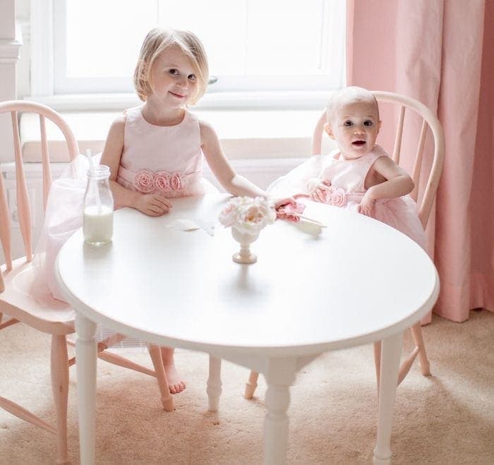 两个小女孩坐在一张桌子旁