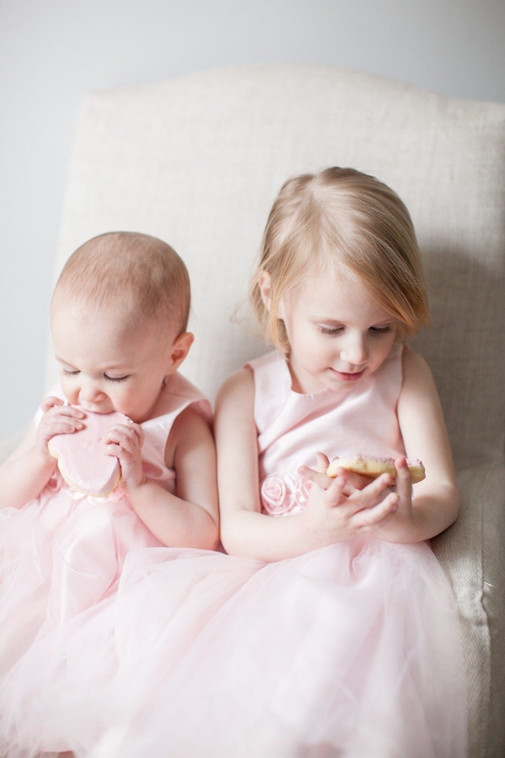 两个小女孩穿着相配的衣服坐在一起。
