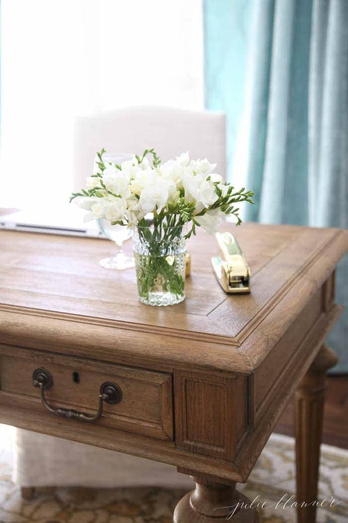 家庭办公室里的木制桌子，顶部的花瓶和金订书机。