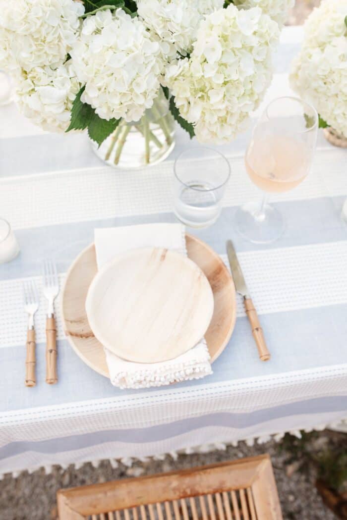 木制板和充电器与白花蓝色和白色台布吃饭在户外。