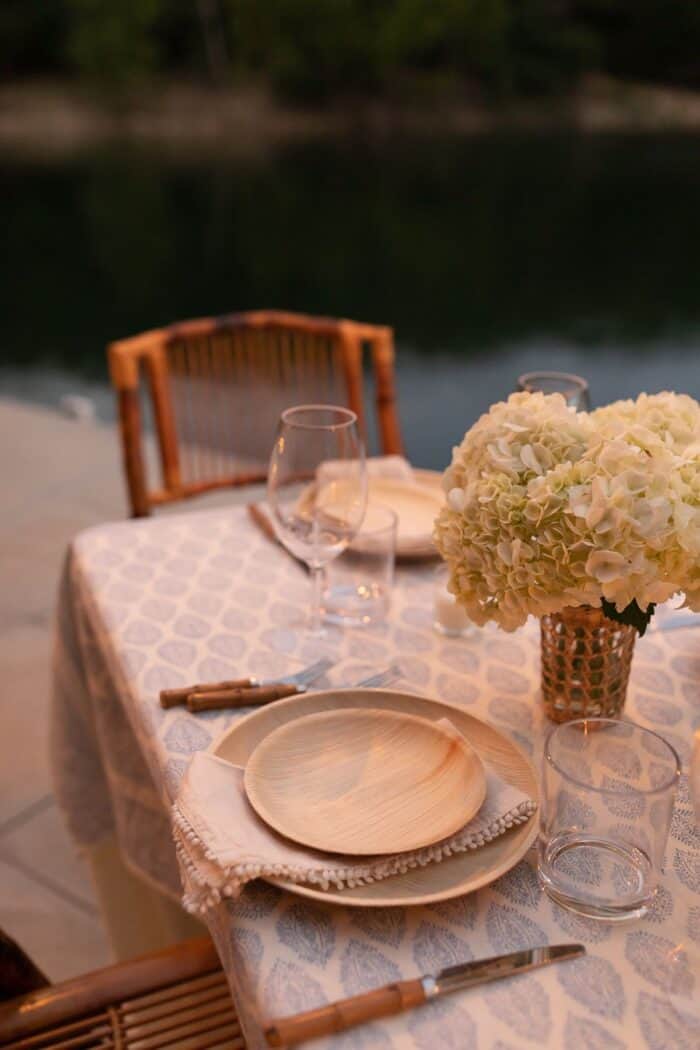 一套表与藤折叠椅和白色的花朵在码头吃饭在户外。