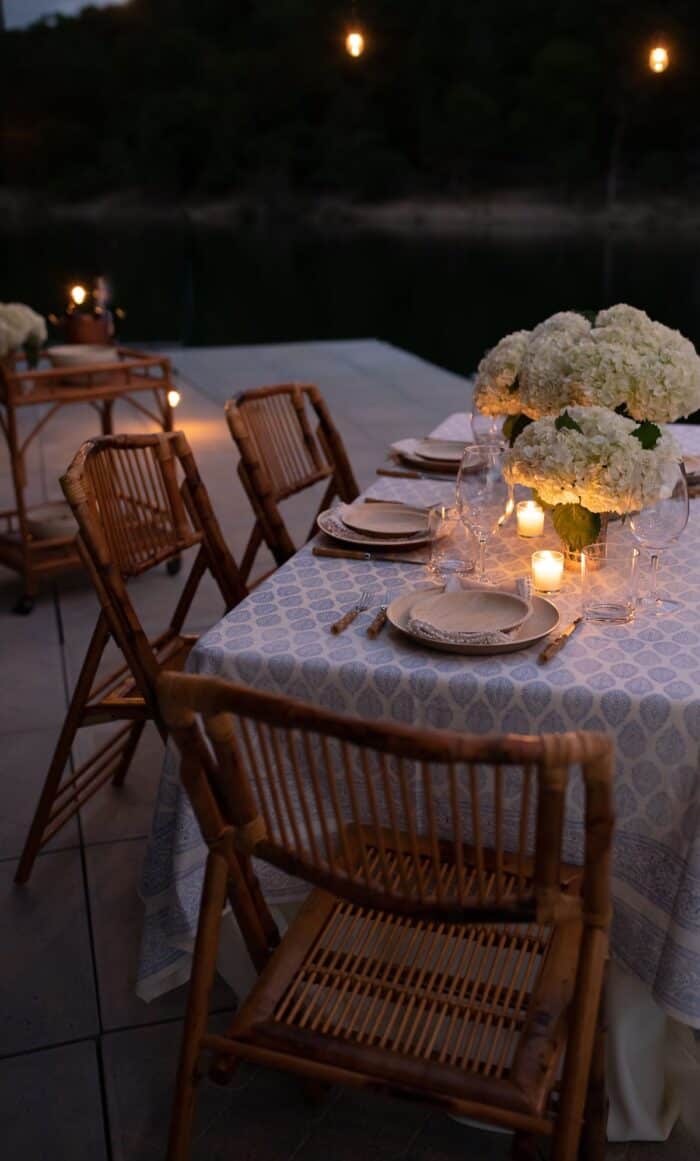 一套表与藤折叠椅和白色的花朵在码头吃饭在户外。