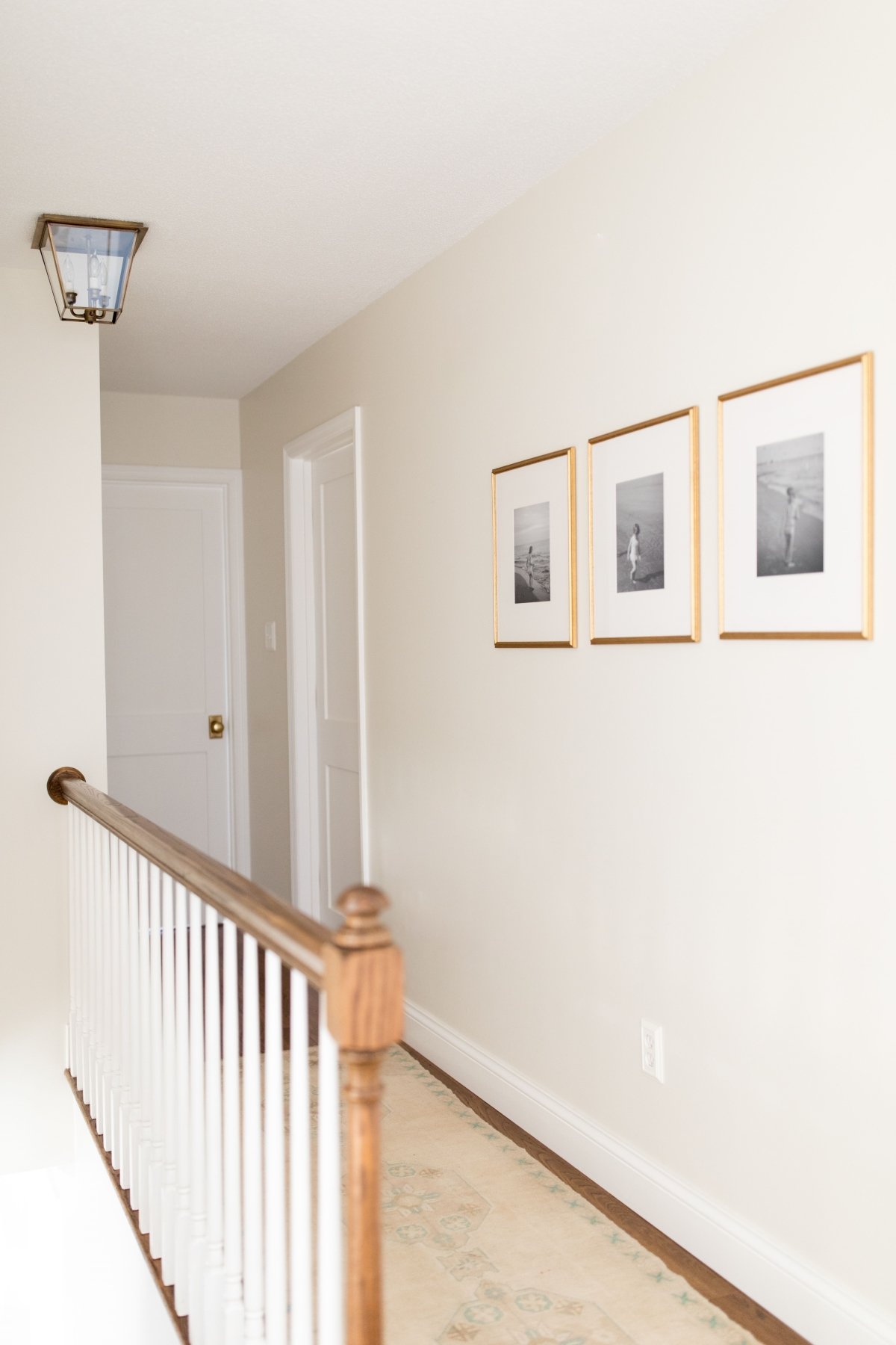 走廊涂奶油油漆颜色,黄铜框架黑白照片在墙上