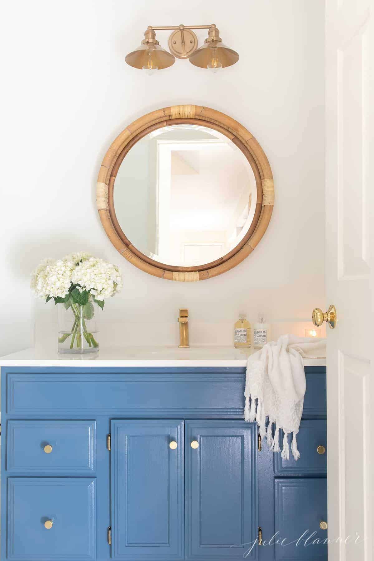 航海浴室配蓝色洗手盆黄铜水龙头圆形藤制镜花和毛巾