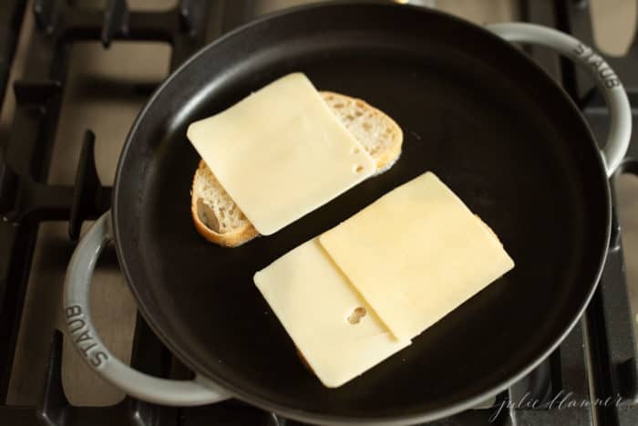 铸铁煎锅，放两片面包片，上面放奶酪片。gydF4y2Ba