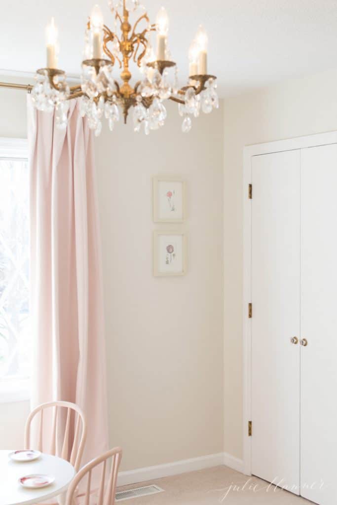 一个粉红色的女孩卧室，带有一个枝形吊灯，为家庭增添个性。