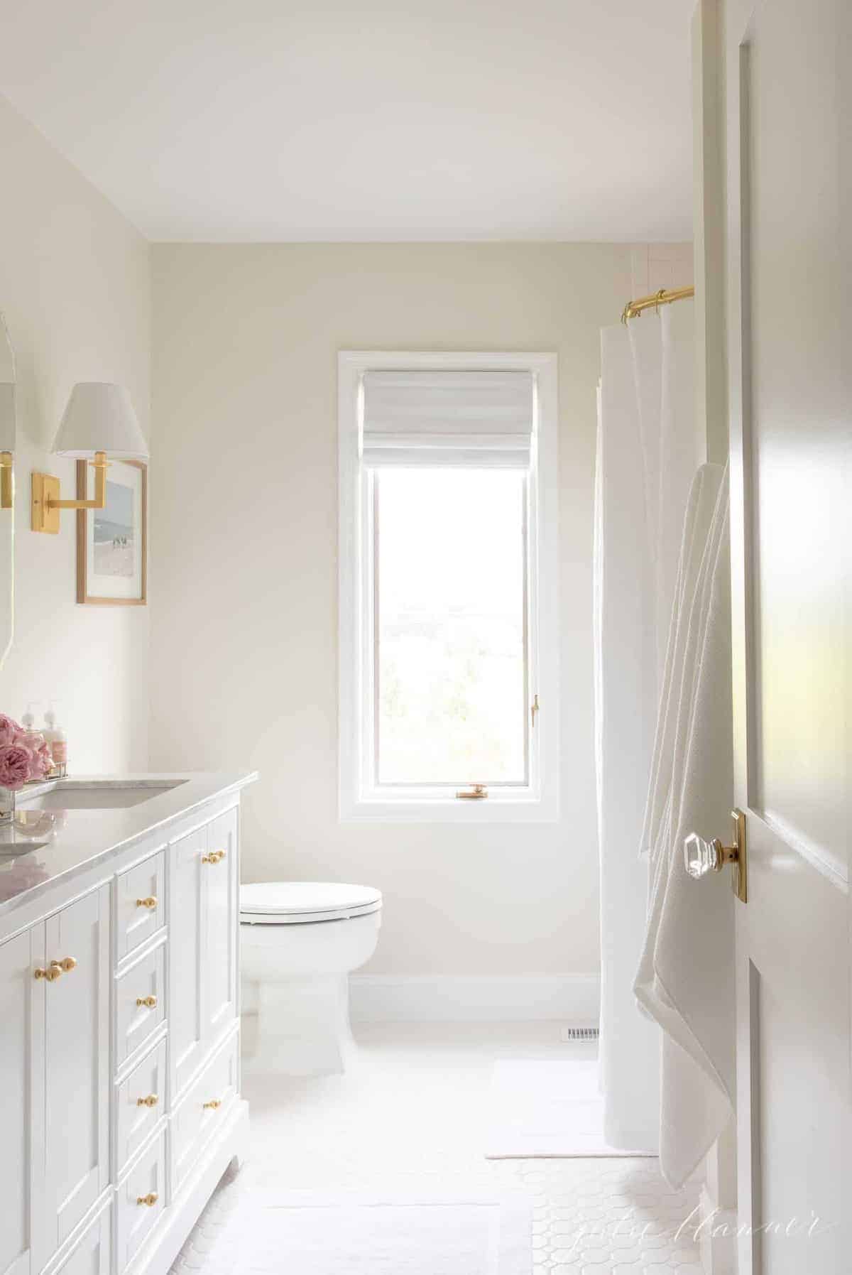 白色水疗启发的家庭浴室，带有金色硬件，可为豪华家居装饰外观。