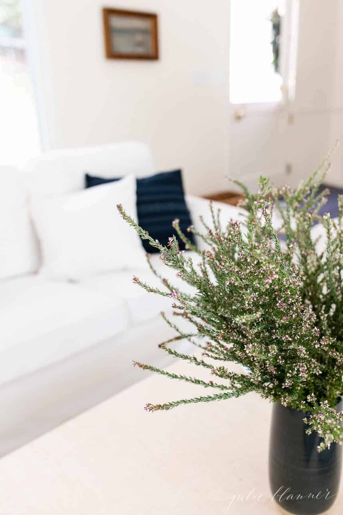 白色客厅与海军枕头和海军花瓶的野花。