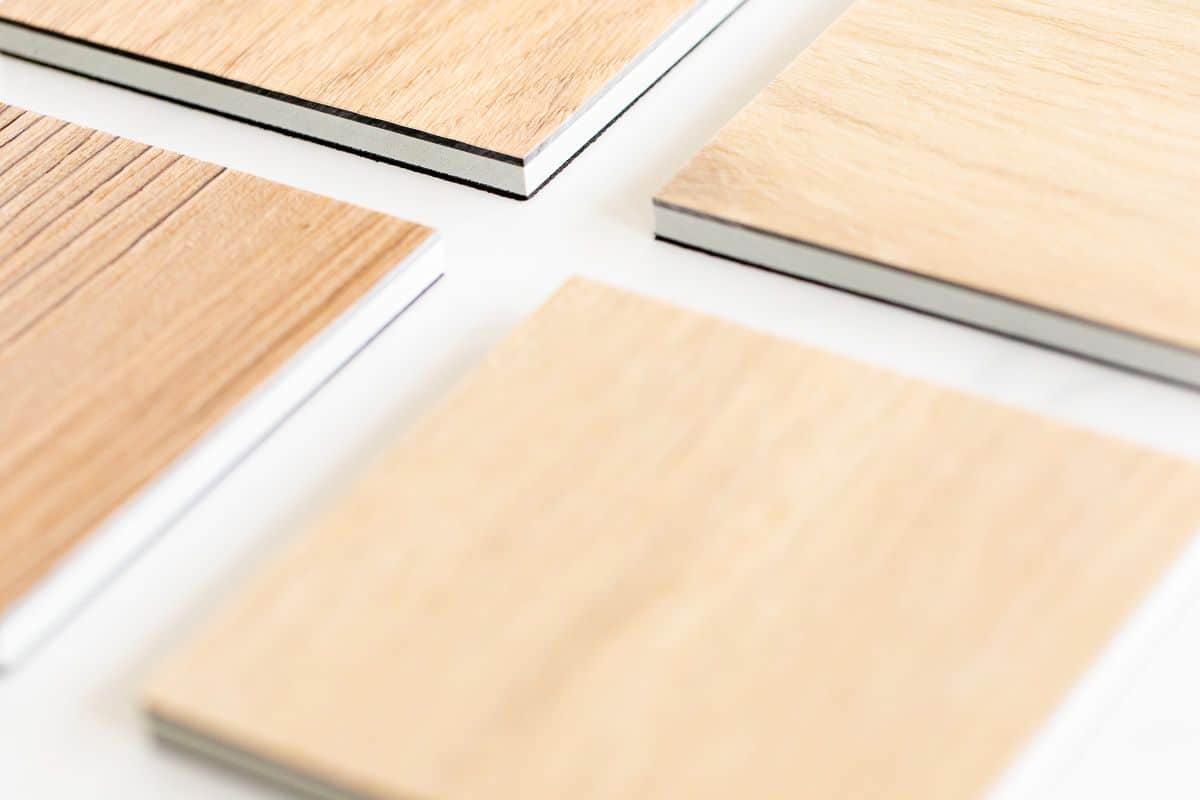 最好的乙烯基板地板的小样品铺在白色的表面上。