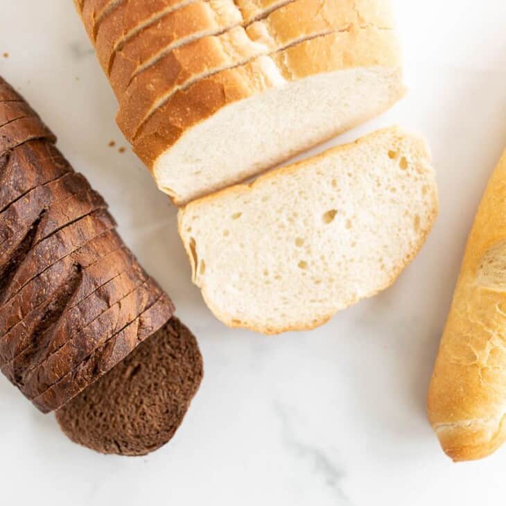 在一个关于烤奶酪最好的面包的帖子里，大理石表面上有三条不同的面包。gydF4y2Ba