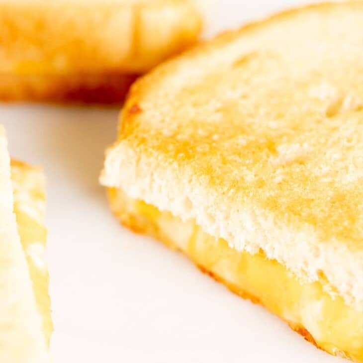 烤箱烤奶酪三明治，在白色的表面切片。gydF4y2Ba