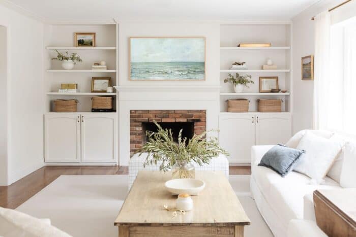 一个小的白色客厅，带有大奶油地毯，白色的墙壁和家具。